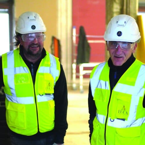 Due tecnici in elmetto e gilet ad alta visibilità in cantiere