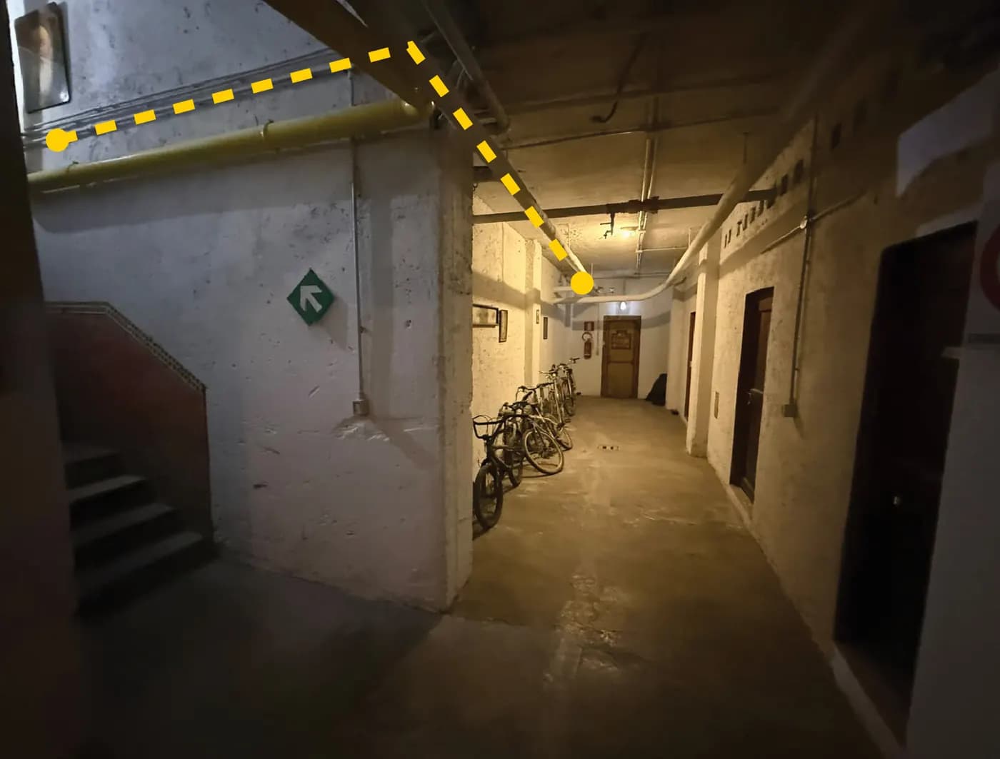 Corridoio del seminterrato con una linea gialla tratteggiata che indica il percorso del cavo lungo il soffitto