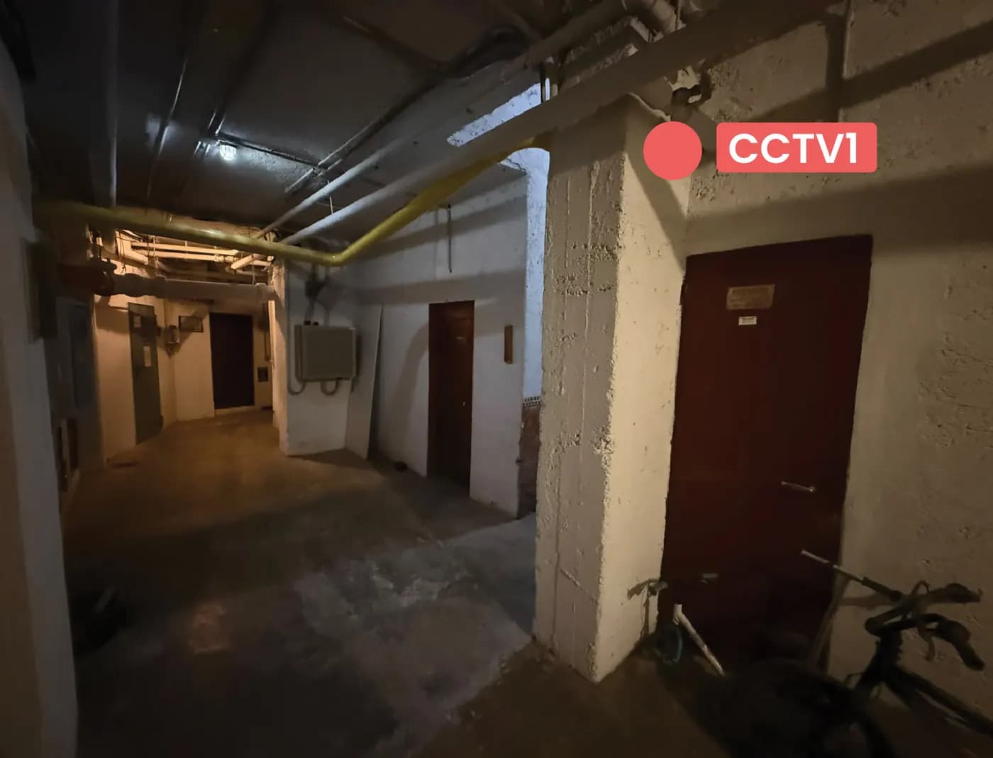 Corridoio del seminterrato con un indicatore rosso CCTV 1 che mostra la posizione proposta della telecamera
