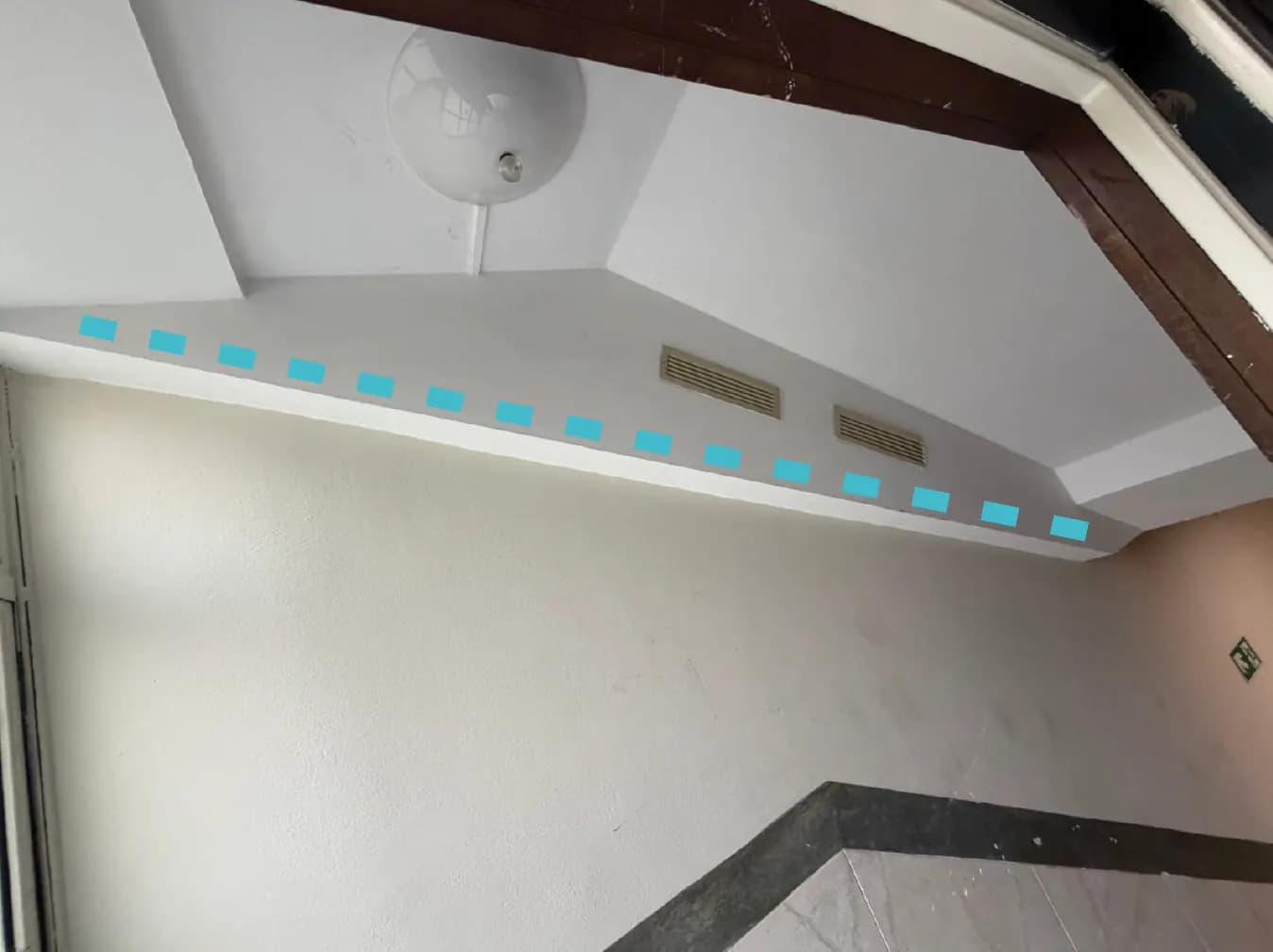 Soffitto di un vano scale con una linea azzurra tratteggiata che indica il percorso nascosto del cavo lungo il cartongesso