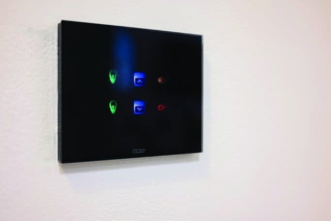 Pannello di comando KNX a pulsanti in vetro nero installato a parete